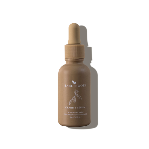Bare Roots Clarity Serum in its amber glass bottle set against a soft light background, emphasizing its natural, targeted formula.