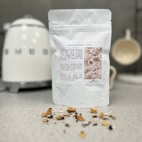 Bare Roots Digestive Tea pouch shown with aromatic loose leaf tea sprinkled in front.