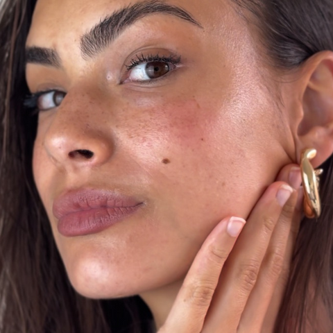 Woman showcasing glowing, refreshed skin after removing Camellia Sheet Mask
