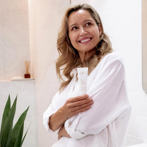 Smiling woman holding Flora Cream tube in her hand