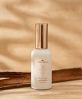 Skincare bottle labeled 'bare roots' on a wooden surface with a natural background