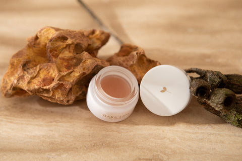 Bare lips open jar against earthy background