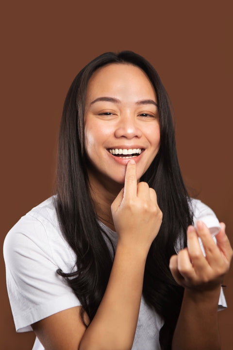 Model applying bare lips with finger