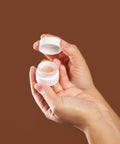 model holding bare lips open jar