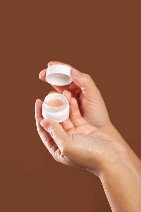model holding bare lips open jar