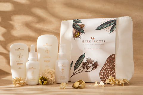 Collection of Bare Roots skincare products on a wooden surface with a natural background.