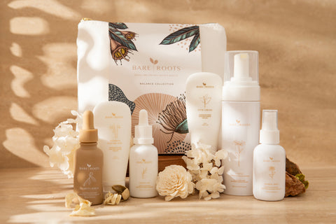 Collection of Bare Roots skincare products on a wooden surface with a warm background