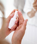 Woman dispensing Curative Serum onto her fingertips for application.