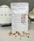 Bare Roots Digestive Tea pouch shown with aromatic loose leaf tea sprinkled in front.