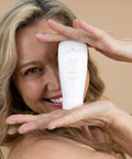 Woman smiling while holding Bamboo Enzyme Peel tube in hand