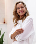 Smiling woman holding Flora Cream tube in her hand