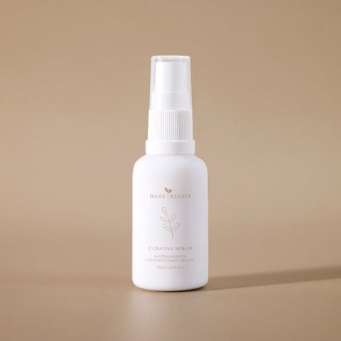 Curative Serum amber dropper bottle against a beige background.