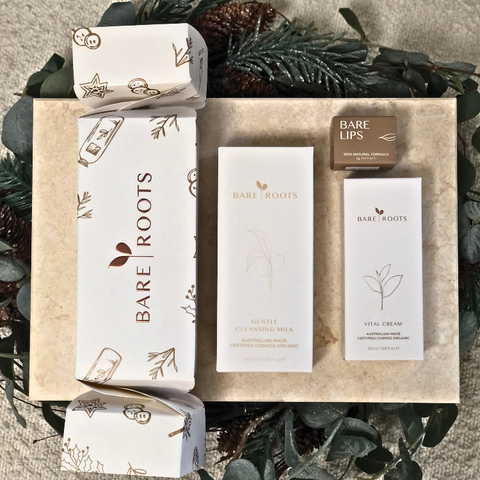 Bare Roots skincare products with decorative greenery on a textured surface