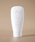 White tube of Bare Roots skincare product on a beige background