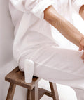 Gentle Cleansing Milk tube resting on a chair beside a seated woman