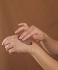 plant peel rubbed into hand against brown background