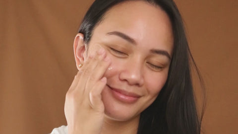 video of model applying marigold cleansing balm to cheek