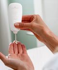 Woman squeezing a small amount of Vital Cream from the tube onto her hand.
