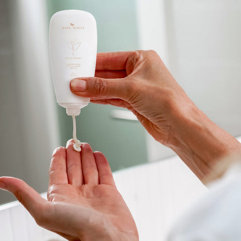 Woman squeezing a small amount of Vital Cream from the tube onto her hand.