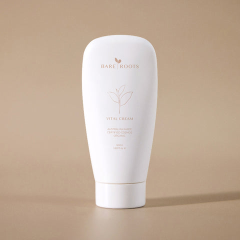 Vital Cream tube standing upright against a soft beige background.